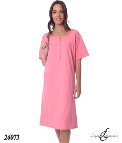 Pink knee-length short-sleeve nightgown with a buttoned placket and embroidery on the yoke, worn by a smiling model in a product photo.