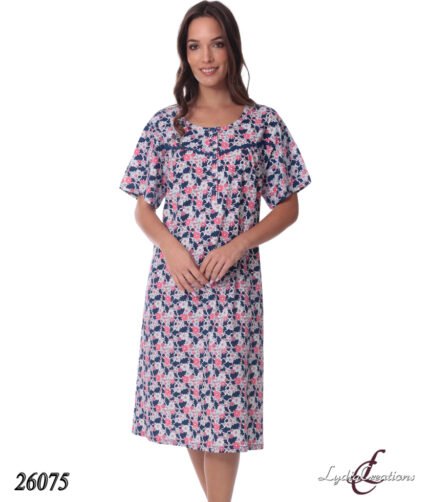 Knee-length floral dress on a woman with pink, white, and navy flowers, short sleeves, standing with hands clasped; product number 26075.