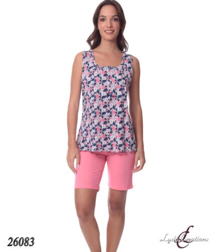 Woman modeling a navy floral sleeveless top with pink flowers paired with pink shorts against a white background.