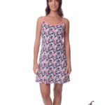 Woman wearing a navy blue and white floral nightgown with pink trim, knee-length and spaghetti straps, standing and smiling.