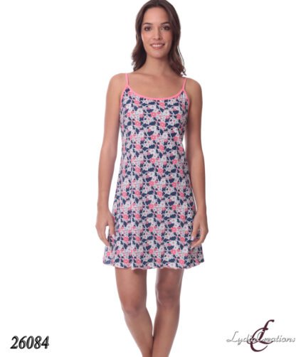 Woman wearing a navy blue and white floral nightgown with pink trim, knee-length and spaghetti straps, standing and smiling.