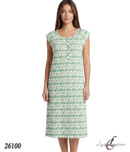 Model wearing a knee-length white dress with a green leaf pattern and cap sleeves, facing forward.