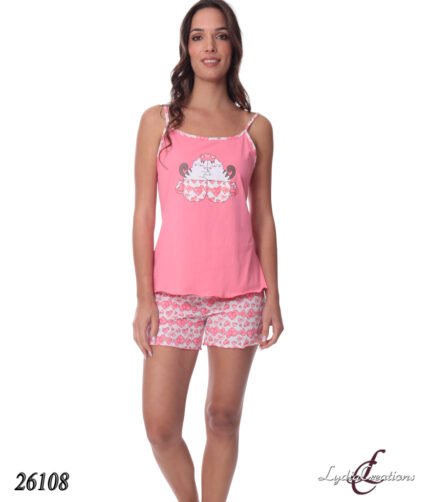 Full-body shot of a woman in pink sleepwear: a tank top with a playful animal graphic and heart-pattern shorts, standing and smiling.